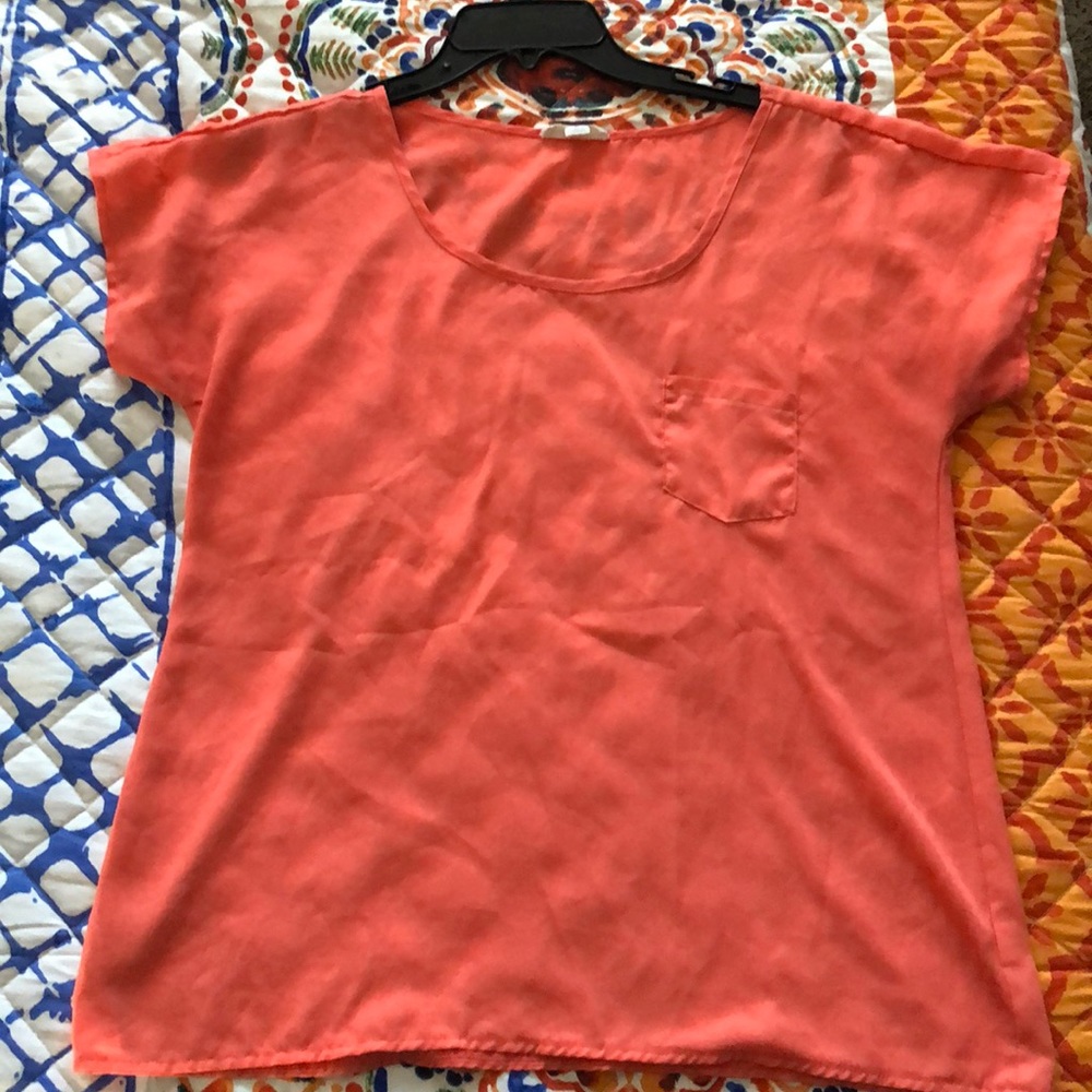 Women’s coral blouse with pocket.